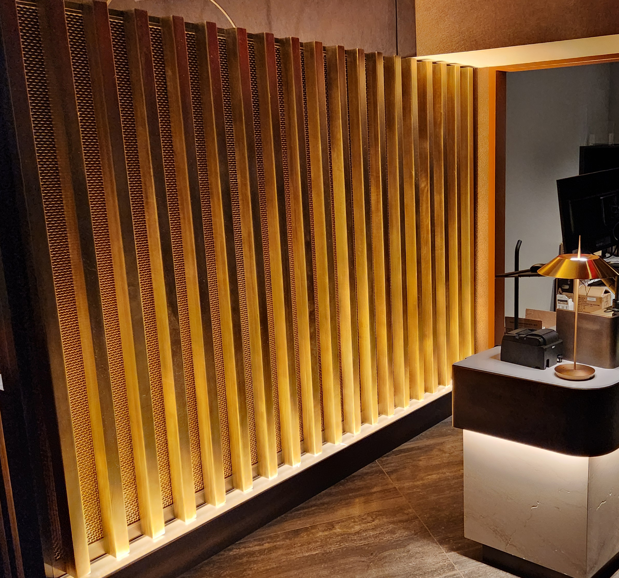 brass partition behind receptionist desk