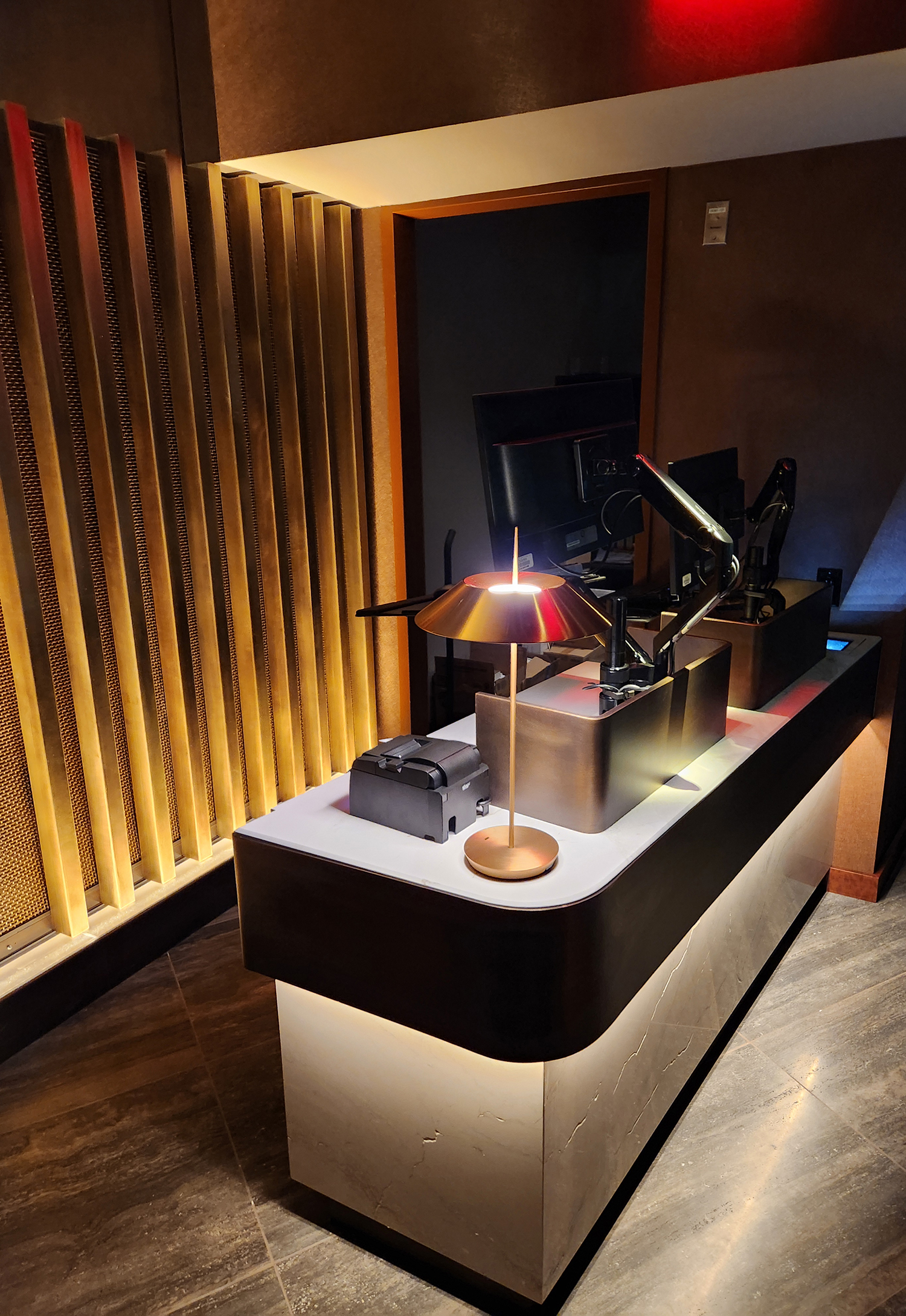 Receptionist table for airport lounge with brass and bronze accents